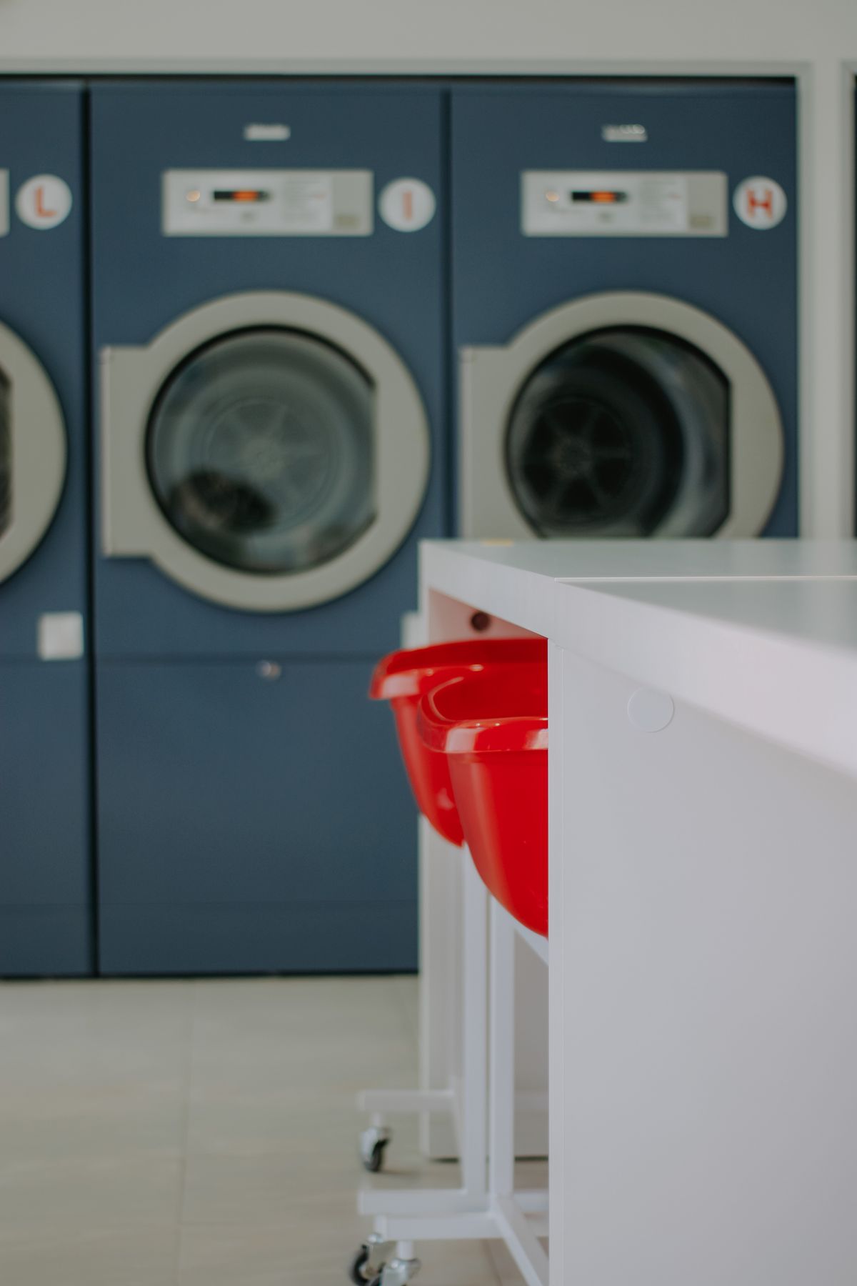 A bright laundromat with blue front-loading washing machines